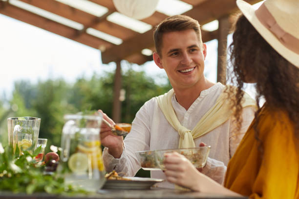 istock Young Couple Enjoying Dinner Outdoors at Summer Party 1264985424