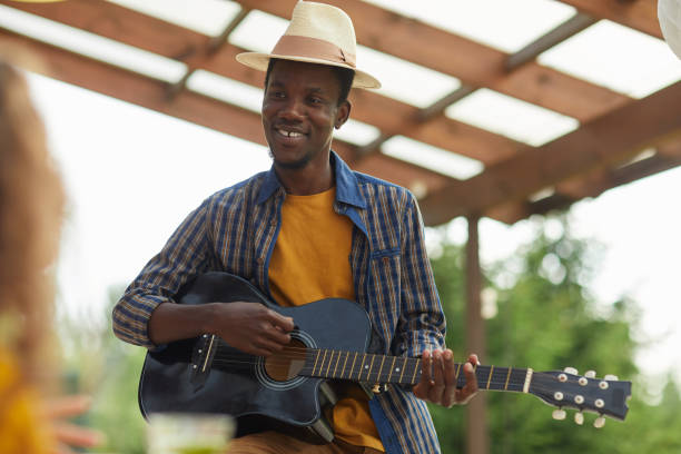 istock African-American Man Playing Guitar Outdoors with Friends 1264985490