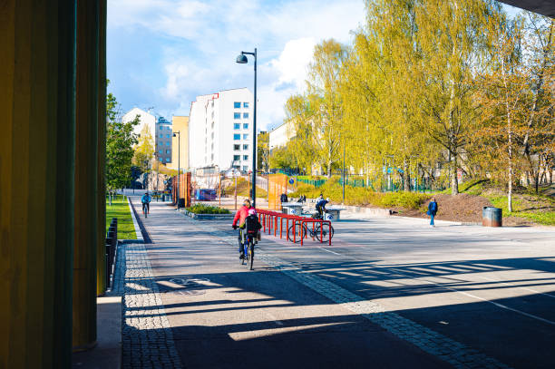 A woman bicyclist riding with her children on a bicycle lane at downtown Helsinki stock photo