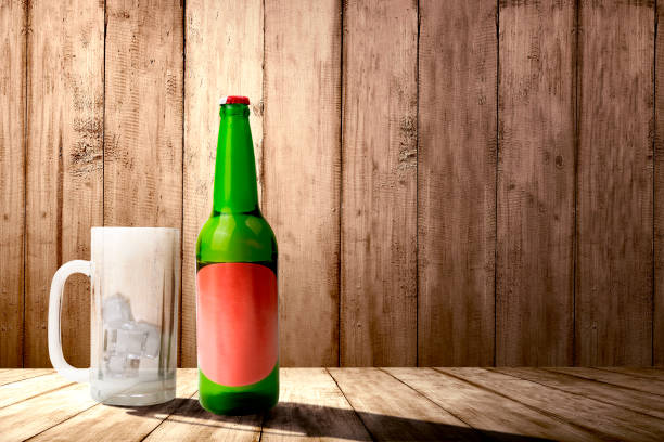 istock Beer bottle and empty glass with ice cubes on the table 1264991322