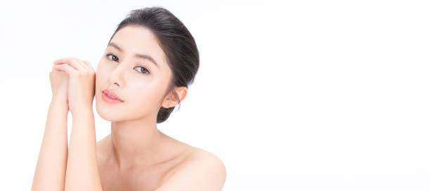 closeup portrait of beauty asian woman with fair perfect healthy glow skin hand touch shoulder copy space, young beautiful asia girl with pretty smile on face. beauty korean clinic skincare concept banner - clear sky human skin women smiling imagens e fotografias de stock