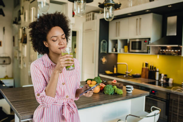 istock Woman using smart phone and drinking smoothie 1264997836