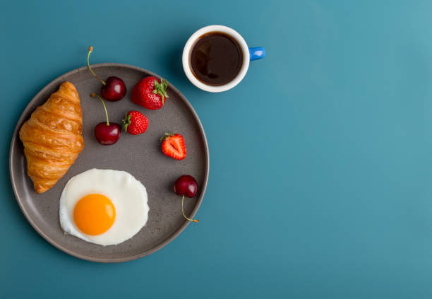 istock Minimal breakfast at blue background with coffee and croissant 1264998255