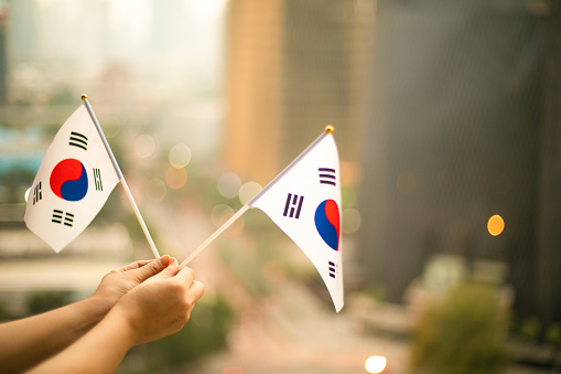 Korean concept. Businessman showing thumb up on the background of flag of Korea