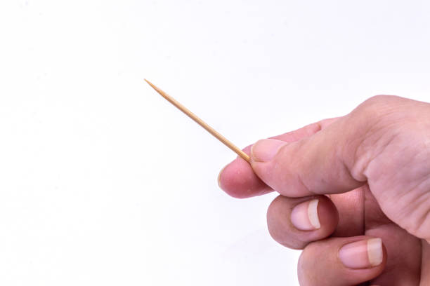 istock Close up hand holding wooden toothpick isolate on white background. 1265000223