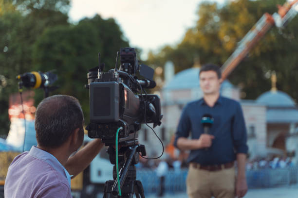 Behind the scene concept. Cameraman working on professional camera taking TV interviewer, professional news reporter making news outdoors. USA, Industry, Movie, Television Industry, Broadcasting movie sound clips stock pictures, royalty-free photos & images