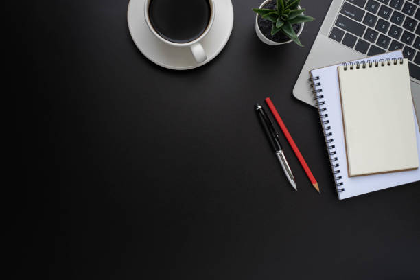 istock Black office desk table with laptop, notebook and coffee cup with equipment other office supplies. Business and finance concept. Workplace, Flat lay with blank copy space, Top view. 1265000417