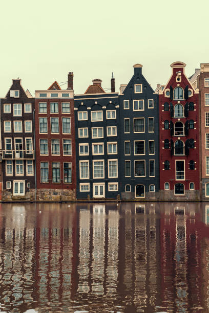 istock Amsterdam, Netherlands, famous dancing houses with reflection in river Amstel, vertical image 1265001430