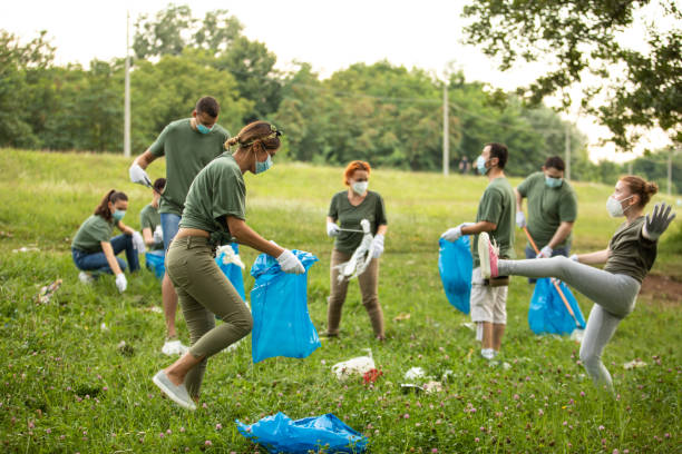 istock Volunteers having fun while cleaning public park together 1265004121
