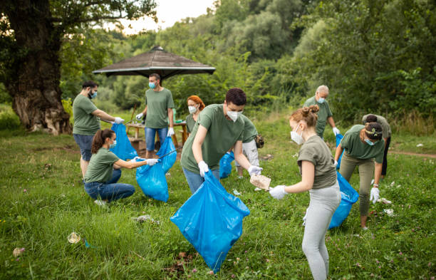 istock Mother teaching daughter about social responsibility while cleaning public park alongside other volunteers during coronavirus pandemic 1265004227