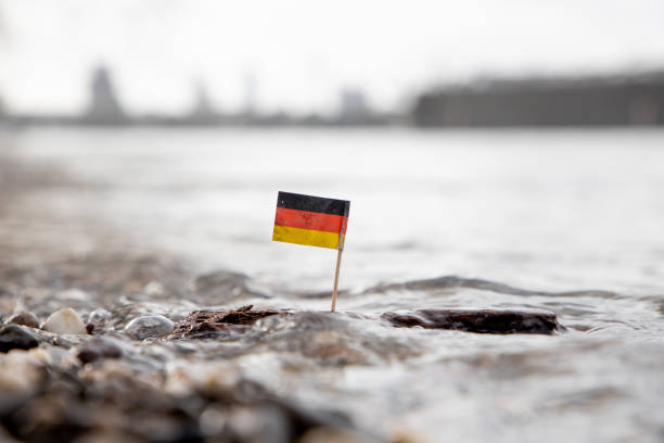 German Flag on Wood in Water Difficulte Times in Germany. German Flag sticking in a piece of wood at shore german free democratic party photos stock pictures, royalty-free photos & images