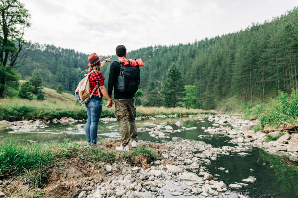istock Young couple exploring nature by the mountain river 1265005686