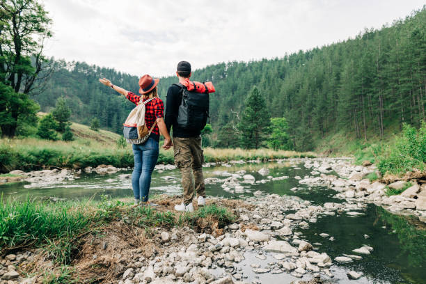 istock Young couple exploring nature by the mountain river 1265005687