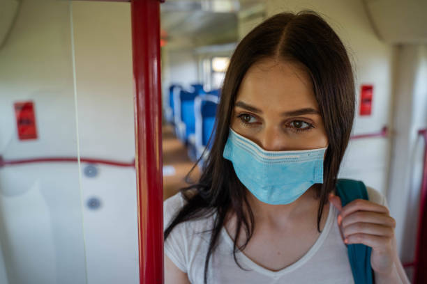 istock Using a protective mask and protective gloves in public transport 1265008534