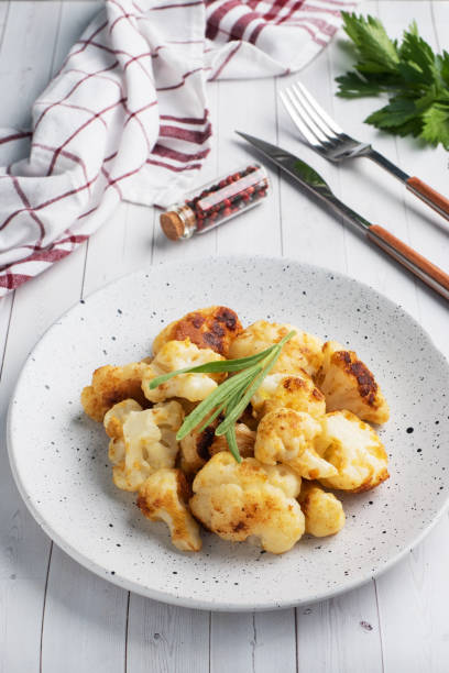 istock Fried cauliflower florets in batter on a white plate. White wooden background. 1265008631
