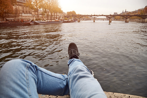 Man sitting on Pont Neuf, Paris, France.