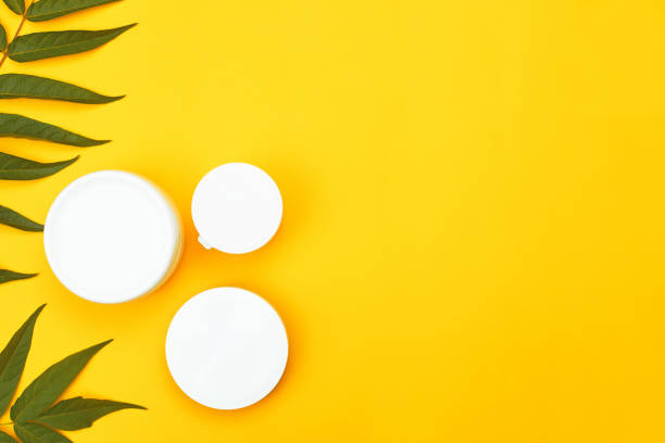 istock three white cosmetic jars against a yellow background, copyspace, flatley, MOCKUP 1265008877