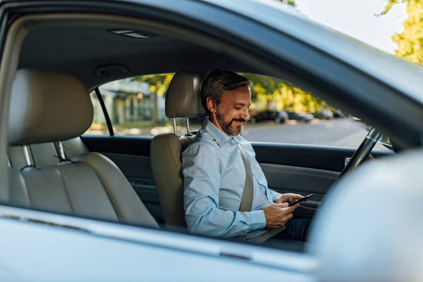 istock Man looking for something on his phone, while spending time in a car. 1265009608