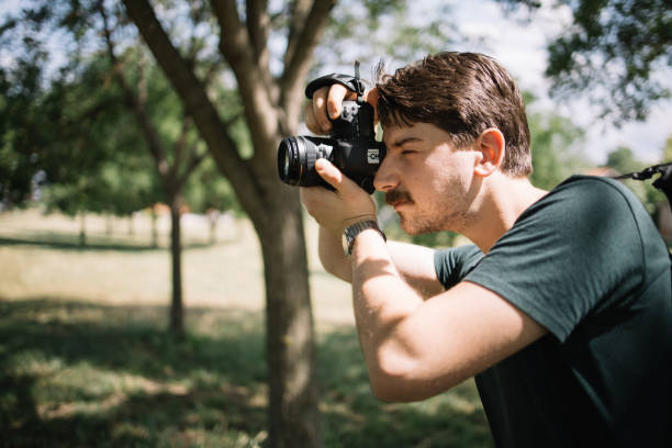istock Side view of man with camera taking photos 1265010188