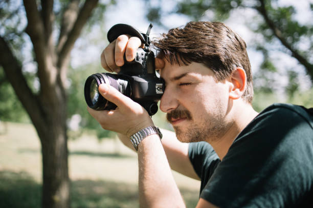 istock Close-up view of man looking through camera viewfinder 1265010239