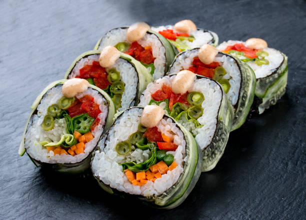 istock Sushi roll with vegetables on black background. Vegetarian dish. 1265011092