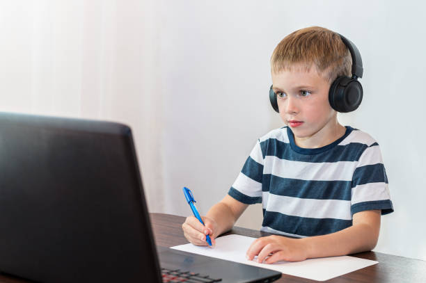 istock Llittle boy with headphones performs an online lesson. Online education. 1265011277