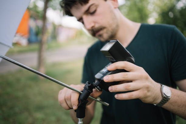 istock Man setting up photographer's equipment for photo session 1265012573
