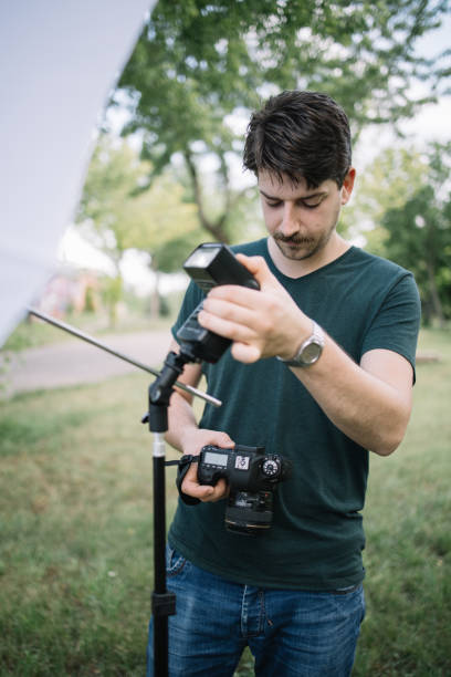 istock Portrait of man looking at camera and setting flash light 1265012695