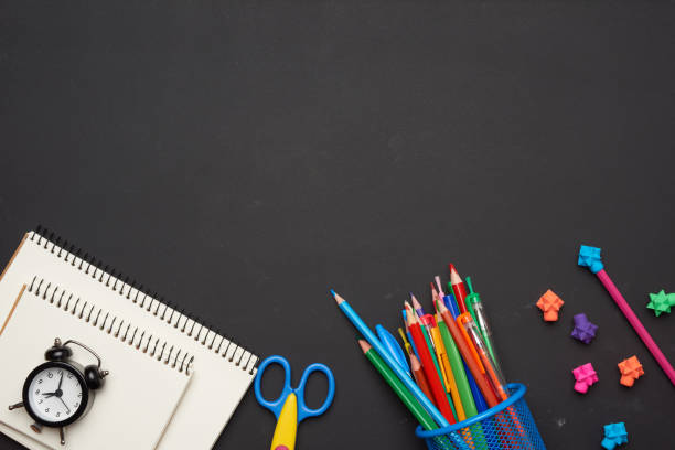 istock colorful wooden pencils, scissors, notepads on a blank black chalk board 1265012730
