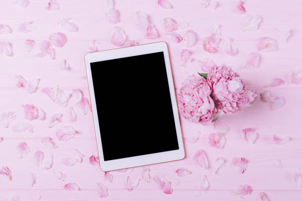 istock Electronic tablet with blank screen next to bouquet of fresh peony flowers 1265012856