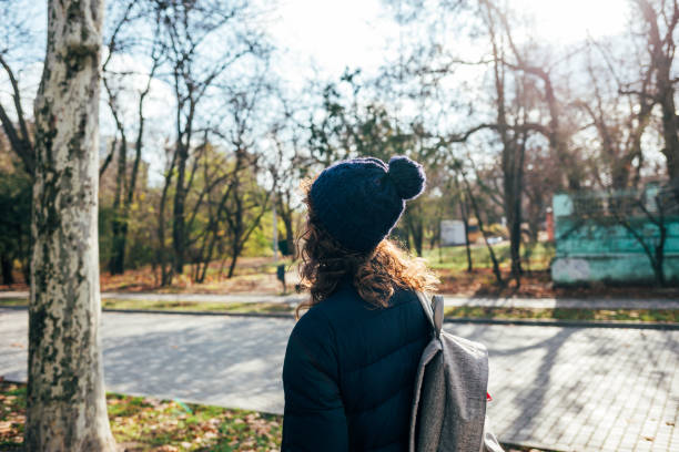 istock Woman with a blue jacket and a knitted hat walks 1265012873