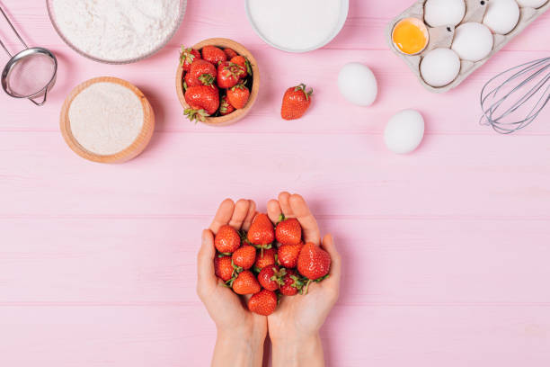 Female hands hold handful of fresh strawberries