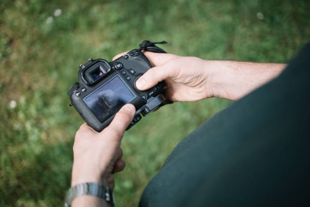 istock Cropped man holding camera and checking photos 1265013245