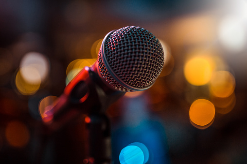 close-up stage microphone with blurry lights in the background