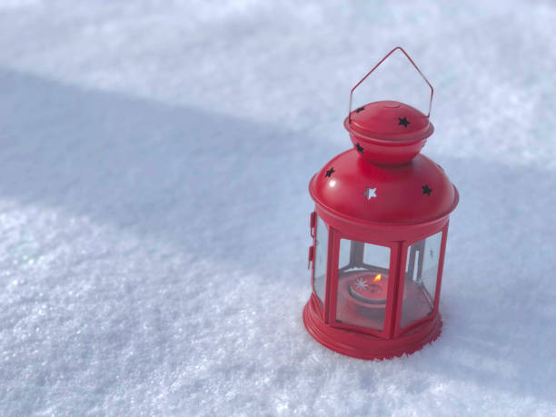istock red candle christmas lantern in snow. Candle burning. Copy space. Christmas concept 1265019711