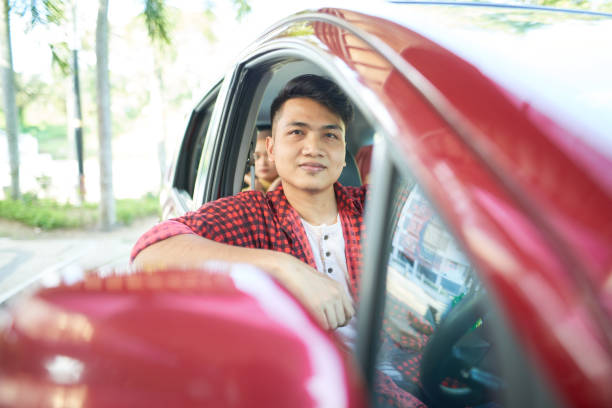 istock Asian e-hailing driver and woman passenger in hijab 1265025125
