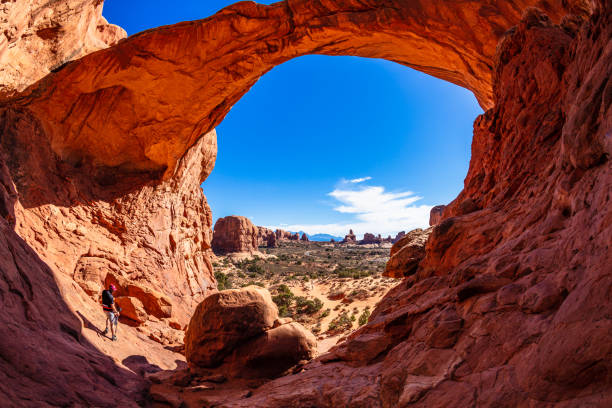Arches National Park Moab, Utah USA - November 3, 2016: Visitors enjoying the natural beauty of the Double Arch rock formation in Arches National Park. hiking arches national park utah climbing stock pictures, royalty-free photos & images