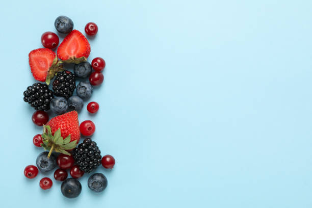 istock Mix of fresh berries on blue background, top view 1265026486