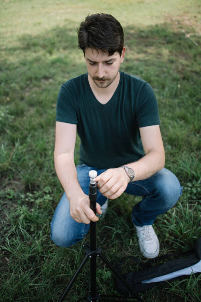 istock Focused man setting up umbrella stand outdoor 1265026672