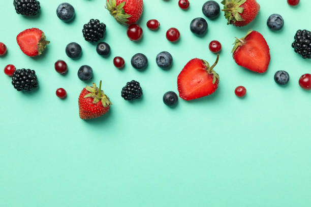 istock Mix of fresh berries on mint background, top view and space for text 1265026766