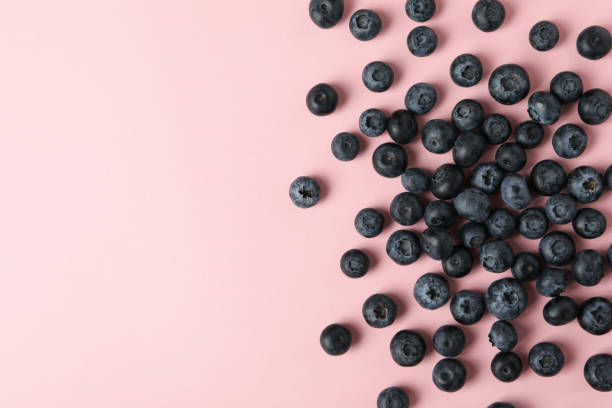 istock Delicious fresh blueberry on pink background, top view 1265026919