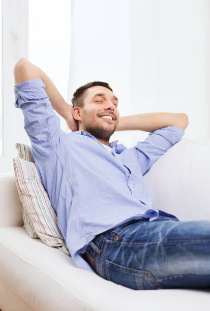 istock smiling man relaxing on couch at home 1265027743