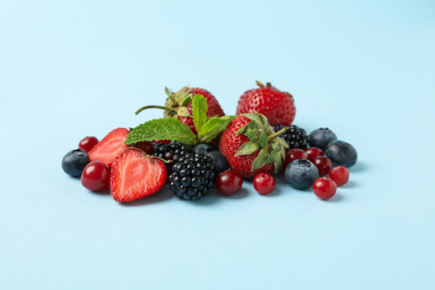 istock Mix of fresh berries on blue background, space for text 1265028444