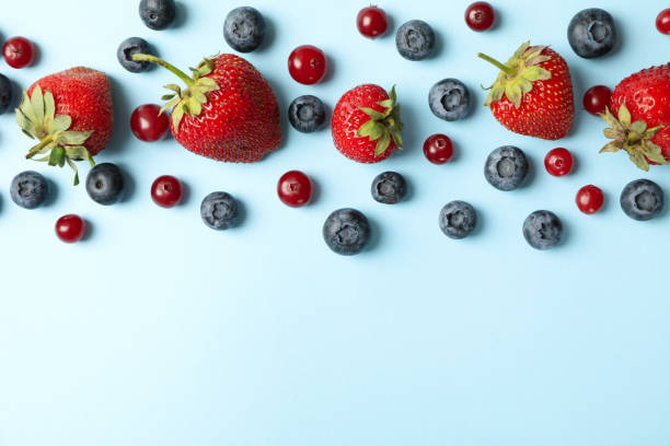 istock Flat lay with fresh berries on blue background, top view 1265028891