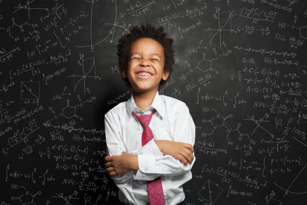 istock Laughing kid student boy on chalkboard background with science formulas 1265028893