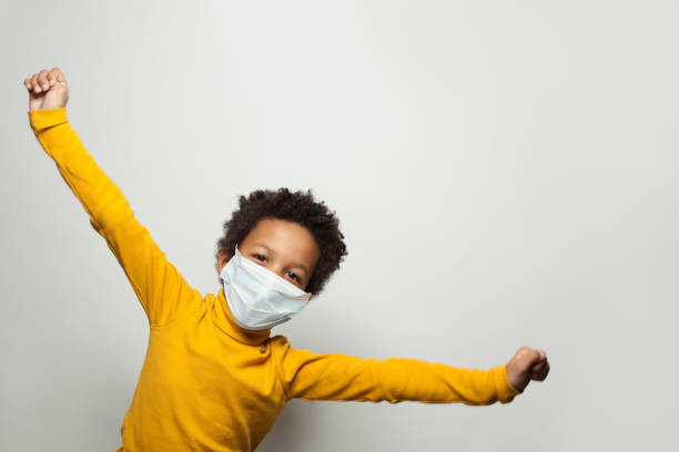 Portrait of funny black child boy in medical protective face mask having fun Portrait of funny black child boy in medical protective face mask having fun primary election photos stock pictures, royalty-free photos & images