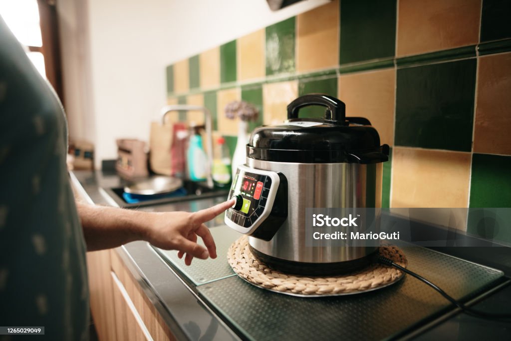 Cooking with an automatic pot A hand programming an automatic pot Crock Pot Stock Photo