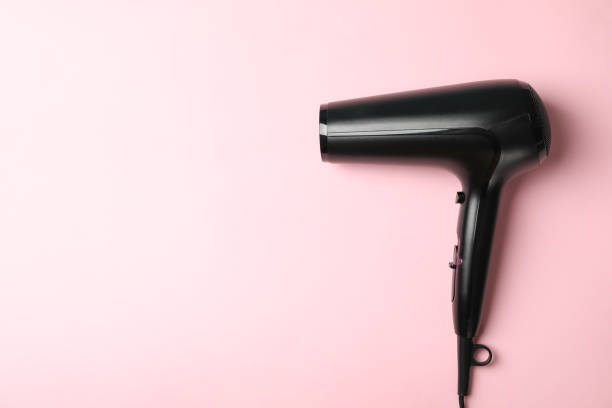istock Black hair dryer on pink background, space for text 1265030343