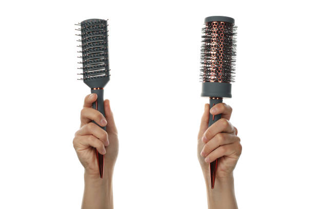 istock Female hands hold hair brushes, isolated on white background 1265030680