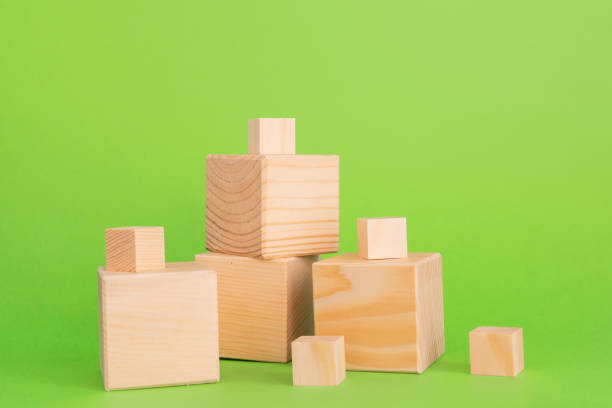 istock Construction of wooden cubes on green background with copy space. Mockup composition for design 1265031578